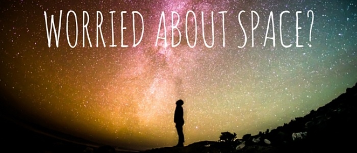 Silhouette of a person gazing at a colorful starry sky with the text 'Worried About Space?' promoting space exploration interest